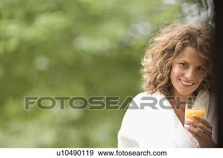 Woman enjoying an orange juice View Large Photo Image Stock Photo - Woman enjoying an orange juice. Fotosearch