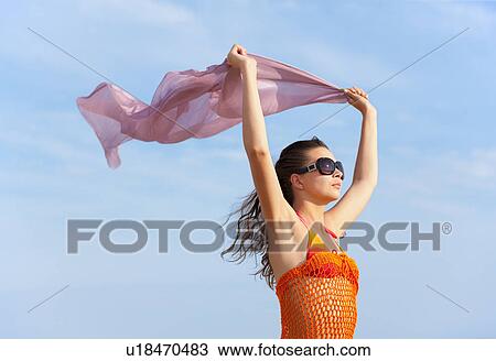 Stock Image - Woman flying cloth at the beach. Fotosearch