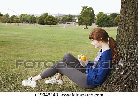 Woman having break, peeling orange View Large Photo Image Stock Photo - Woman having break, peeling orange. Fotosearch
