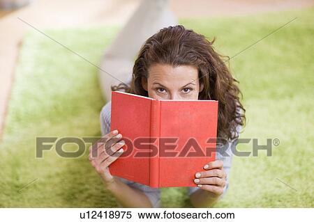 Woman hiding behind a book View Large Photo Image Stock Photography - Woman hiding behind a book. Fotosearch