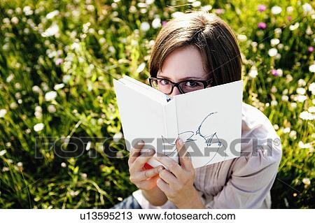 Woman hiding behind book View Large Photo Image Stock Image - Woman hiding behind book. Fotosearch