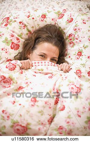 Stock Photograph - Woman hiding in bed. Fotosearch