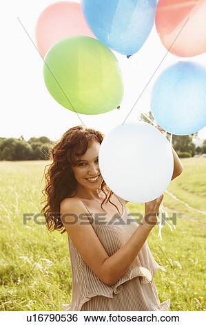 Woman holding bunch of balloons View Large Photo Image Stock Photograph - Woman holding bunch of balloons. Fotosearch