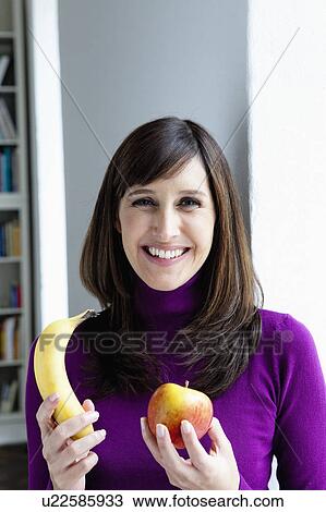 Stock Image - Woman holding fruits. Fotosearch
