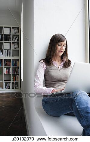 Woman holding notebook on lap View Large Photo Image Stock Image - Woman holding notebook on lap. Fotosearch