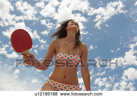 Woman holding racket seen from below View Large Photo Image Stock Photo - Woman holding racket seen from below. Fotosearch