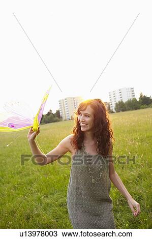 Stock Image - Woman holding toy butterfly. Fotosearch