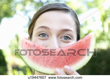 Woman holds up smiley water melon View Large Photo Image Stock Photo - Woman holds up smiley water melon. Fotosearch