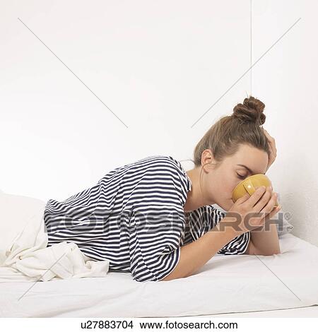 Woman in bed drinking from mug View Large Photo Image Picture - Woman in bed drinking from mug. Fotosearch