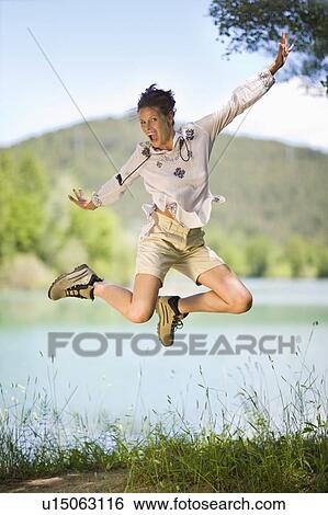 Woman jumping in the air View Large Photo Image Stock Photograph - Woman jumping in the air. Fotosearch