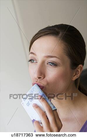 Stock Image - Woman kisses bank notes. Fotosearch