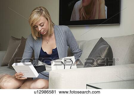 Stock Image - Woman looking at gift in box. Fotosearch
