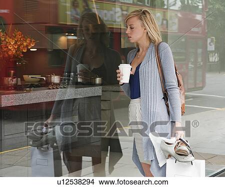 Woman looking in shop window View Large Photo Image Picture - Woman looking in shop window. Fotosearch