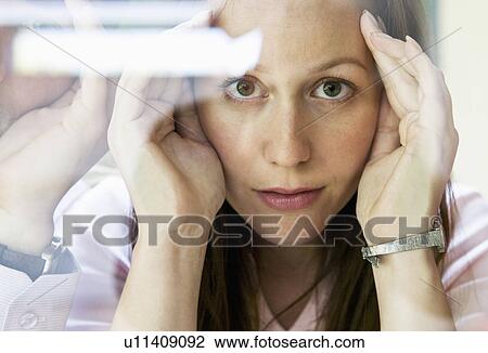 Stock Image - Woman looks thru glass. Fotosearch