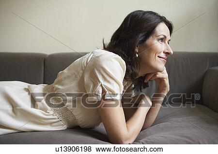 Stock Photo - Woman lying on couch. Fotosearch