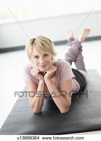 Picture - Woman lying on fitness mat. Fotosearch