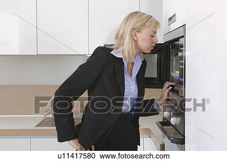 Woman microwaving food View Large Photo Image Stock Image - Woman microwaving food. Fotosearch