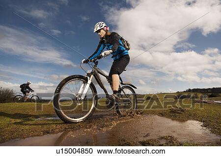 Woman mountain biking in countryside View Large Photo Image Stock Image - Woman mountain biking in countryside. Fotosearch