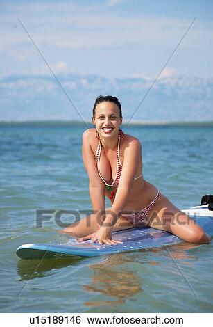Woman on surfboard at the beach View Large Photo Image Stock Photograph - Woman on surfboard at the beach. Fotosearch