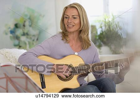 Stock Photo - Woman playing guitar. Fotosearch