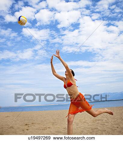 Woman playing volleyball at the beach View Large Photo Image Stock Photo - Woman playing volleyball at the beach. Fotosearch