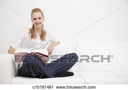 Woman reading a book on sofa View Large Photo Image Stock Image - Woman reading a book on sofa. Fotosearch