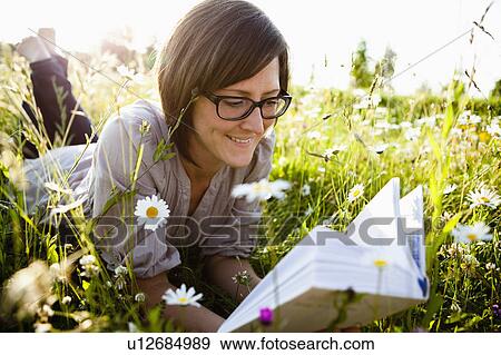 Woman reading book in wild meadows View Large Photo Image Stock Photo - Woman reading book in wild meadows. Fotosearch