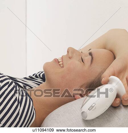 Woman reclined holding alarm clock View Large Photo Image Stock Photo - Woman reclined holding alarm clock. Fotosearch