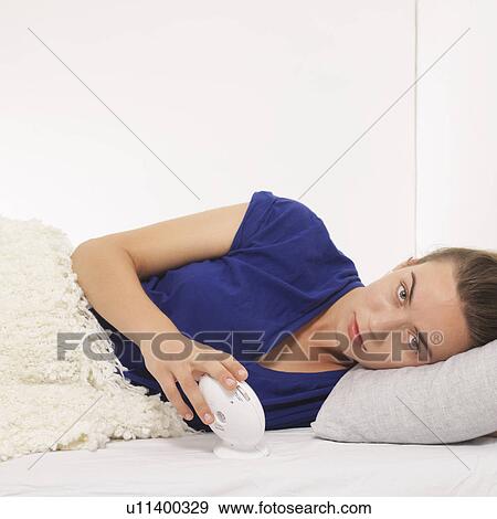 Woman reclined with alarm clock View Large Photo Image Stock Photo - Woman reclined with alarm clock. Fotosearch