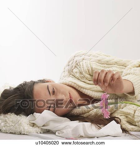 Woman reclined with pink flower View Large Photo Image Stock Image - Woman reclined with pink flower. Fotosearch