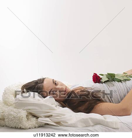 Woman reclined with red rose View Large Photo Image Stock Image - Woman reclined with red rose. Fotosearch