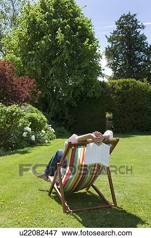 Stock Photo - Woman relaxing deck chair. Fotosearch