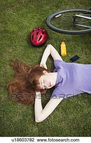 Woman relaxing from bikeride in park View Large Photo Image Stock Image - Woman relaxing from bikeride in park. Fotosearch