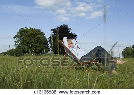 Woman relaxing in deck chair View Large Photo Image Stock Photo - Woman relaxing in deck chair. Fotosearch