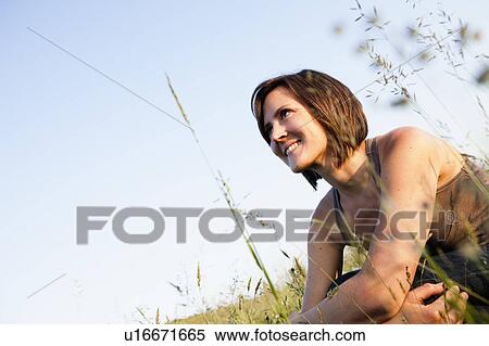 Woman relaxing in field View Large Photo Image Stock Photography - Woman relaxing in field. Fotosearch