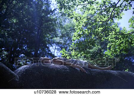 Stock Photo - Woman relaxing on a roc. Fotosearch