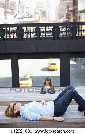Woman resting on a bench, in the city View Large Photo Image Stock Photography - Woman resting on a bench, in the city. Fotosearch