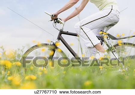 Stock Image - Woman riding bike. Fotosearch