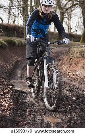 Woman riding mountain bike muddy track View Large Photo Image Stock Photo - Woman riding mountain bike muddy track. Fotosearch