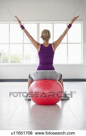 Stock Photo - Woman sitting on gymball. Fotosearch