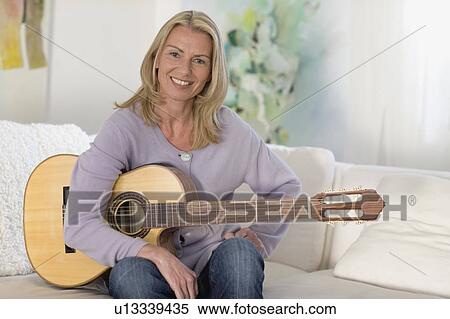 Woman sitting with guitar View Large Photo Image Stock Photography - Woman sitting with guitar. Fotosearch
