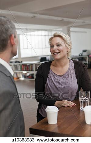 Stock Image - Woman smiling in the break room. Fotosearch