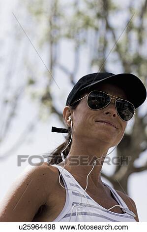 Woman smiling with sunglasses and cap View Large Photo Image Stock Photo - Woman smiling with sunglasses and cap. Fotosearch