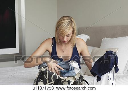 Woman sorting through clothes in bag View Large Photo Image Stock Image - Woman sorting through clothes in bag. Fotosearch