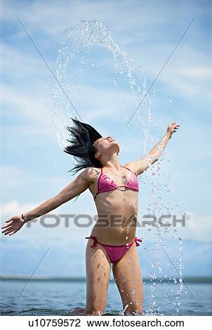 Woman splashing water at the beach View Large Photo Image Stock Image - Woman splashing water at the beach. Fotosearch