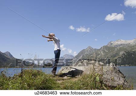 Woman standing on lake with open arms View Large Photo Image Stock Image - Woman standing on lake with open arms. Fotosearch