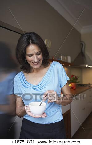Woman stiring up coffee View Large Photo Image Stock Image - Woman stiring up coffee. Fotosearch