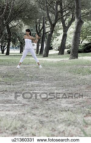 Woman stretching in a park View Large Photo Image Stock Image - Woman stretching in a park. Fotosearch
