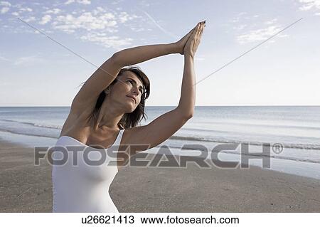 Woman stretching in front of the sea View Large Photo Image Stock Image - Woman stretching in front of the sea. Fotosearch