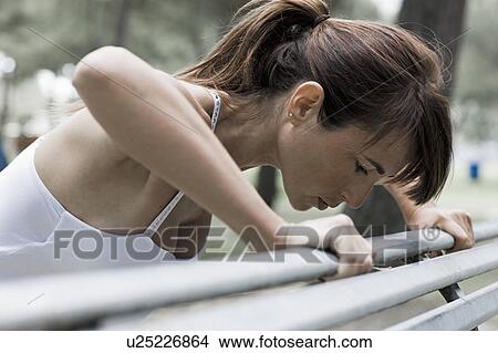 Picture - Woman stretching on a bench. Fotosearch